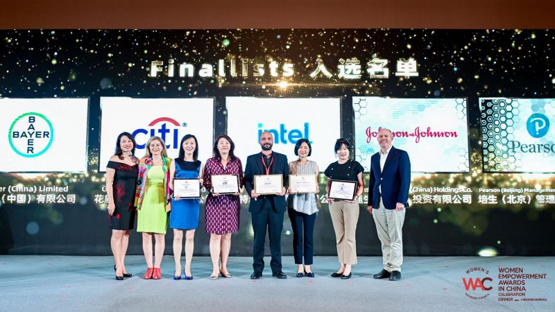 Pearson China team on stage at 2021 Women's Empowerment Awards holding certificates and smiling.