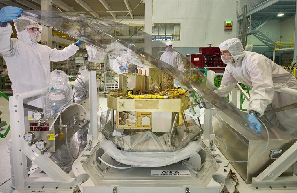 The Webb telescope's NIRISS instrument, being examined by a group of cleanroom engineers and technicians
