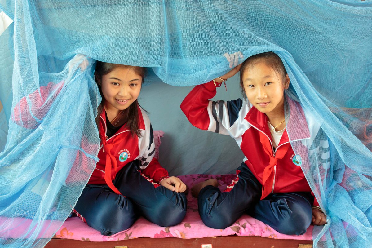 Nan Laodi, from Myanmar, and Huang Pei Pei, a Chinese student, use bed nets every night in their dorm room at the Friendship Primary School in Daluo, which is a few hundred metres from the Myanmar border.  Meng Hai County, Yunnan Province. April 2019.
