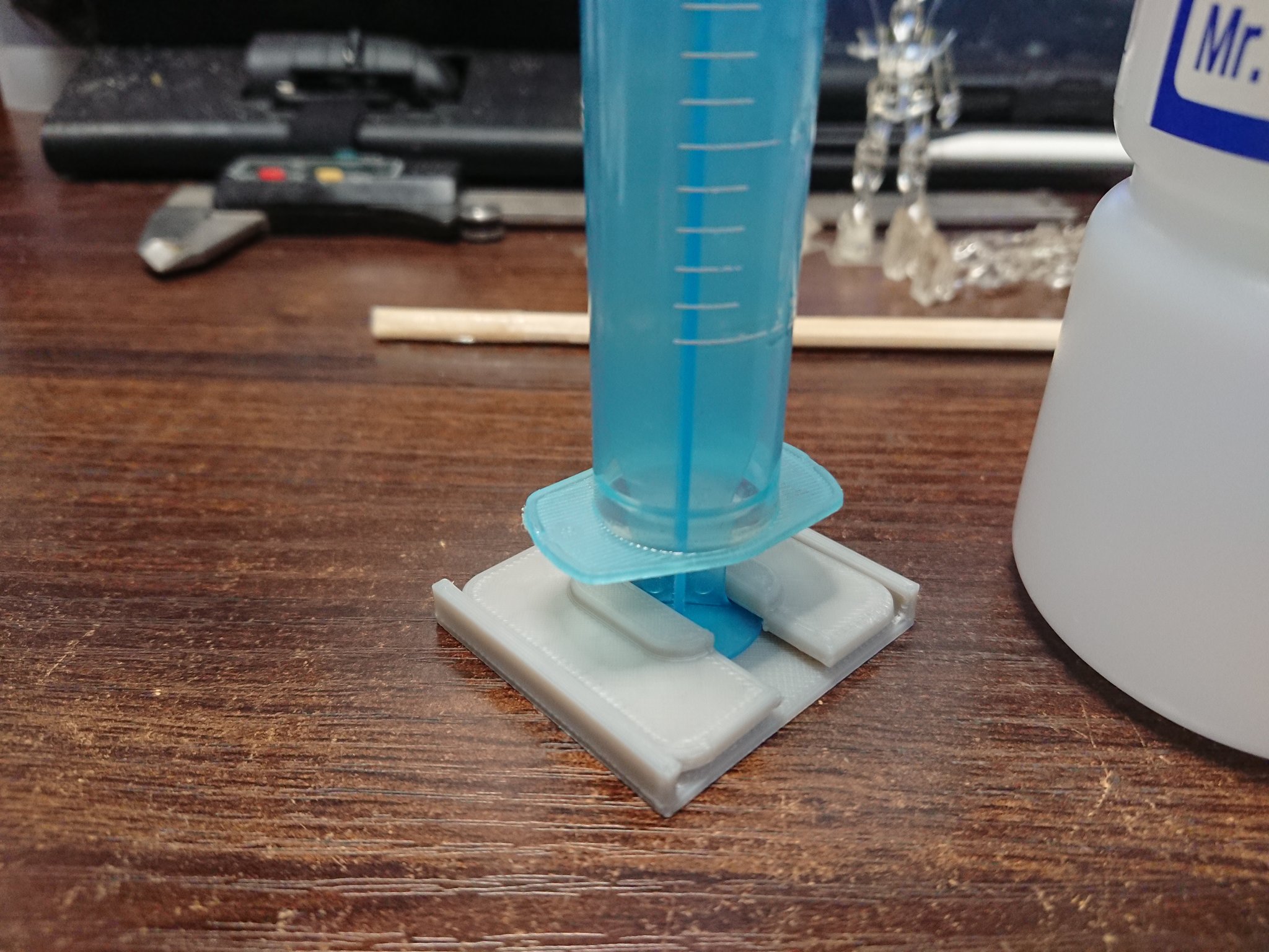 ボンクラーズ総長 薄め液を少し使うのに スポイトの代わりに100均の注射器型の容器を使うも 中身が詰まった状態で倒して置いておくと垂れてくるので 立てて置ける台を作ってみたんだけど このまま置いておくと尖端が危険であぶない感じで失敗である