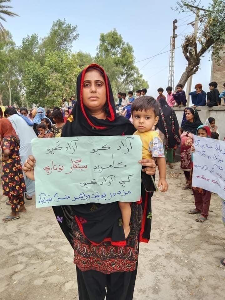 Ali_Sindhii's tweet photo. #ReleaseSeengarNoonari 
Wife of Seengar Noonari holding a placard which says “free my comrades Seengar Noonari” 
His partner is carrying their younger son. #ReleaseSeengarNoonari https://t.co/iW9KAPF2c5