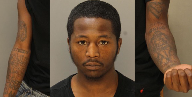 Photo of Nadir Mitchell's face and of the tattoos covering both of his arms.