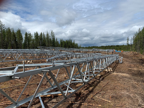 wataynikaneyap's tweet photo. An assembly crew builds structures at a fly-yard near #NorthCaribouLake First Nation. When this picture was taken in early June, the crew had built 26 structures with over 100 more structures to go for this #WatayPower transmission line segment. #IndigenousOwnership https://t.co/DMZjhYjmLD