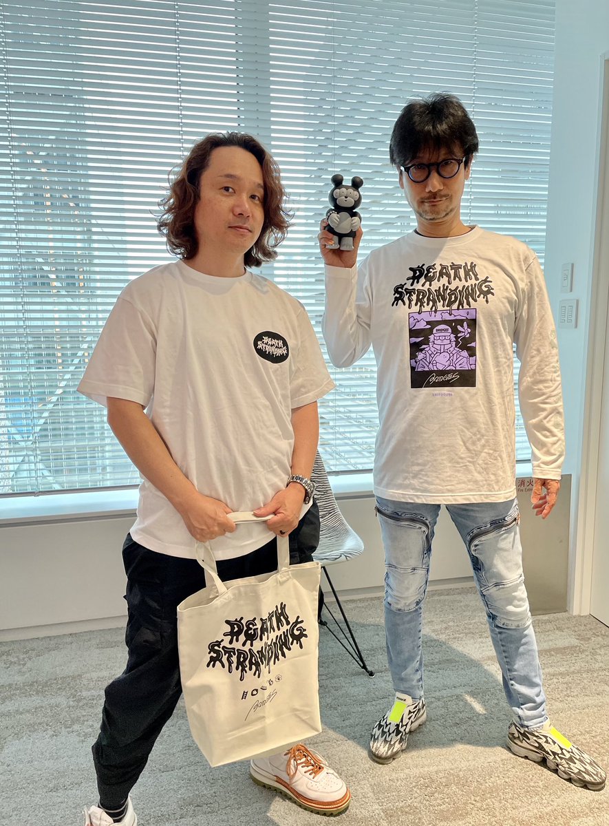 Kojima_Hideo's tweet photo. DEATH STRANDINGとBRIDGE SHIP HOUSEさんとのコラボ商品。サンプルを着てみた。左の２つは僕がフーディ(バックプリント)、しんちゃんは長T。右の２つは僕が長T、しんちゃんは半袖T(バックプリント)にトートバック。他にも商品あり。

VILLAGE VANGUARD ONLINE STOREで受注販売中。受注期間は7/11まで。 https://t.co/roiXehcGDH
