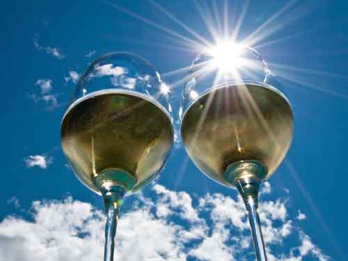 Розовое шампанское в бокале. Рюмка в руке. Бокал с вином. А мы бокалы к небу поднимаем. Солнце в бокале.