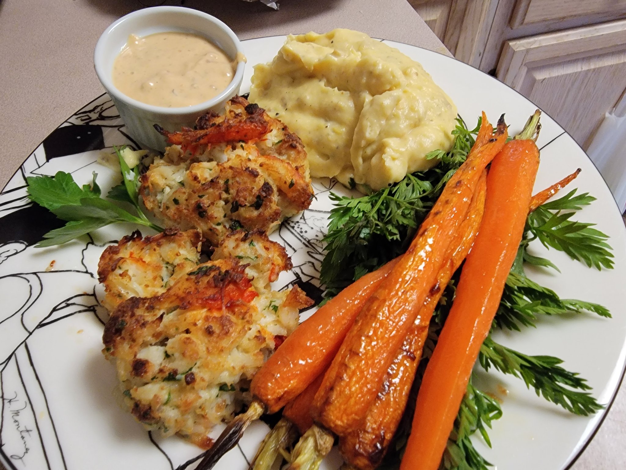 Crab lobster cakes w side of creol remoulade sauce, served with parmesan yukon golds and roasted heirloom