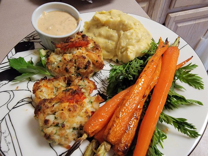 Crab lobster cakes w side of creol remoulade sauce, served with parmesan yukon golds and roasted heirloom