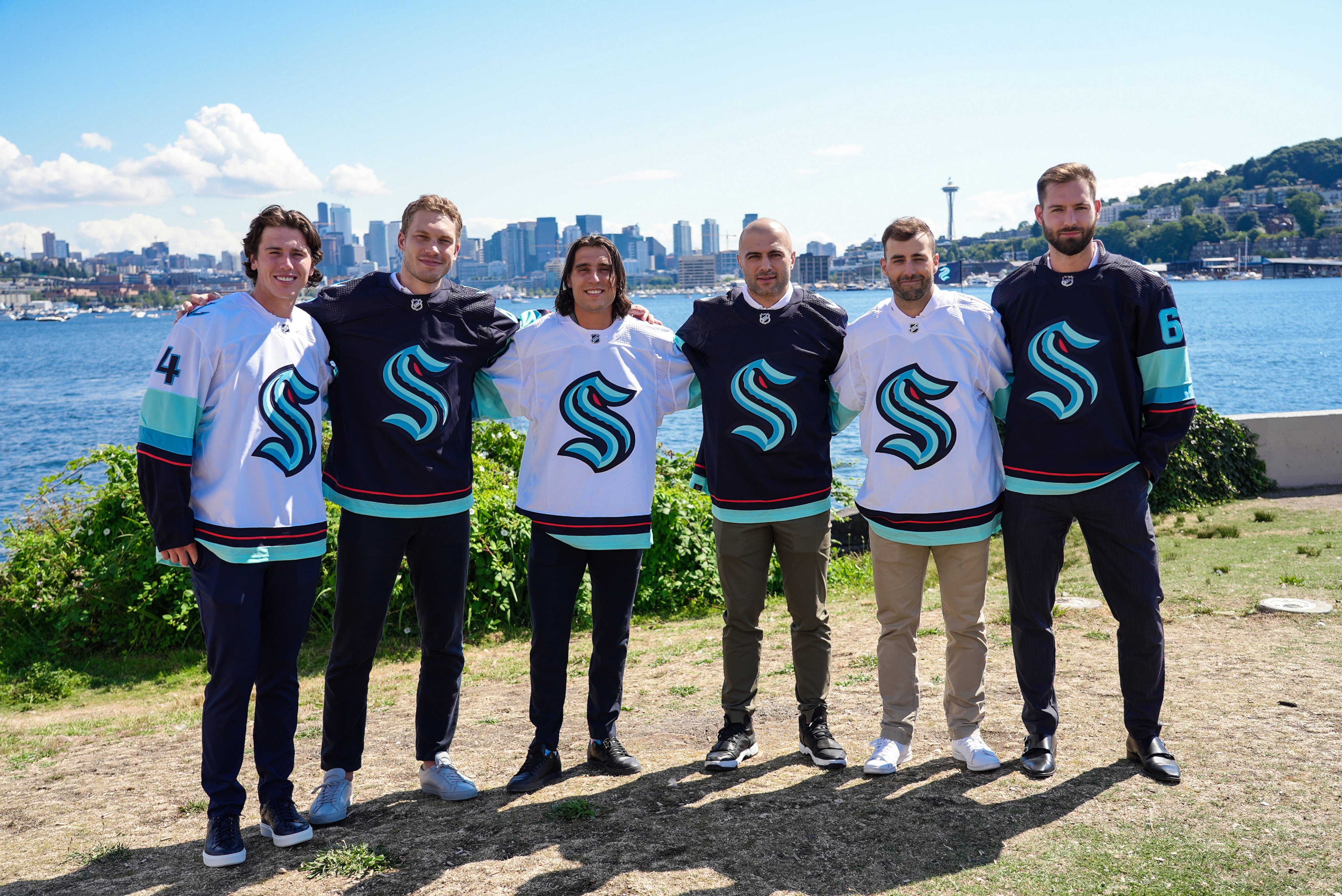 (left to right) Haydn Fluery, Jamie Oleksiak, Brandon Tanev, Mark Giordarno, Jordan Elebre and Chris Driedger posing in the new kraken jerseys at Gas Works park post-Expansion draft