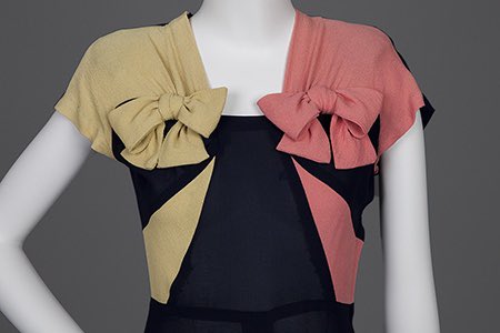 kateStrasdin's tweet image. #Colourblocking is an effective decoration in #1940s tricot knit design. Mostly dark navy, the brighter decorations have been pieced in a mustard and coral bow, contrasting on each side of the body, emphasising the then fashionably square shoulders @GoldsteinMuseum #dresshistory