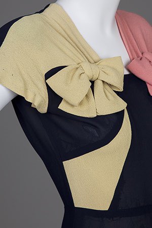 kateStrasdin's tweet image. #Colourblocking is an effective decoration in #1940s tricot knit design. Mostly dark navy, the brighter decorations have been pieced in a mustard and coral bow, contrasting on each side of the body, emphasising the then fashionably square shoulders @GoldsteinMuseum #dresshistory