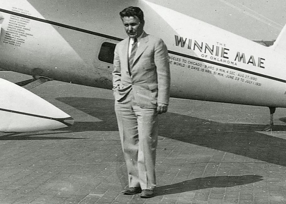 Wiley Post standing in front of his Winnie Mae.