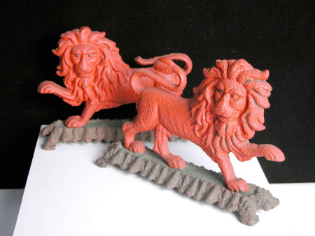 Two red lion doorstops, each with raised paw.