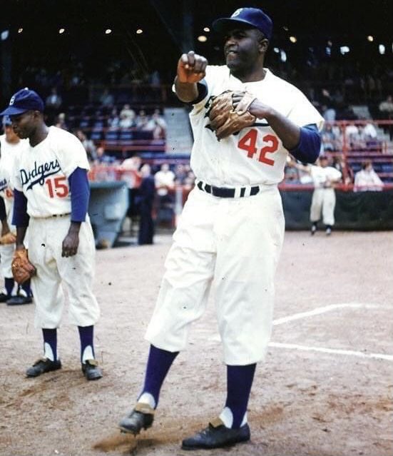 1955. Ebbets Field. Jackie Robinson tosses the ball with Sandy Amoros in the background. The Dodgers would win the World Series that year, the first time ever for them. 3 years later they would move to Los Angeles.