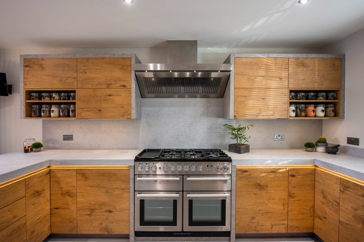 A fantastic combination of quartz and wood gives this kitchen a warm and vibrant tone, whilst still keeping a conservative finish. The U-Shaped layout features a multitude of upstands, which adapt to each walls detail and a standout butler sink. A truly great job by our fitters