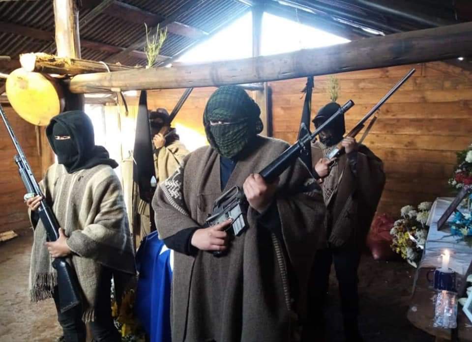 LuisPardoS's tweet photo. Sujetos armados con M-16 custodiando el féretro del terrorista abatido en La Araucanía tras enfrentamiento con Carabineros. ¿Qué está esperando la fiscalía para actuar de inmediato ante el delito flagrante por Ley de Control de Armas? @FiscaliadeChile https://t.co/FNjlZwSiZI