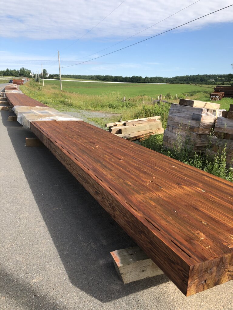 woodatlantic's tweet photo. Since 2019, the Dillman Bridge in Nova Scotia, Canada has been out of commission.
It's amazing to see all these huge glulam beams laid along the road for the new bridge. 3 of them are interconnected to reach 118ft long.

#masstimber #timberbridges #engineering #bridgeengineering https://t.co/5dLWD450Wm