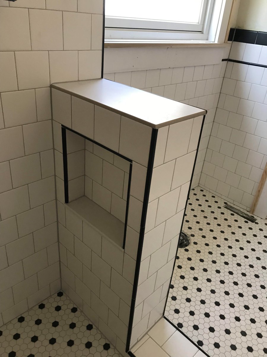 We installed mosaic tile on the bath floor, poured custom shower pan and installed mosaic tiles. Ceramic tiles in the shower surround and on wainscoting in offset pattern with black rope tile trim on open edges. 

#tiling #remodelingcontractors #denvertiles #experttouchtiling