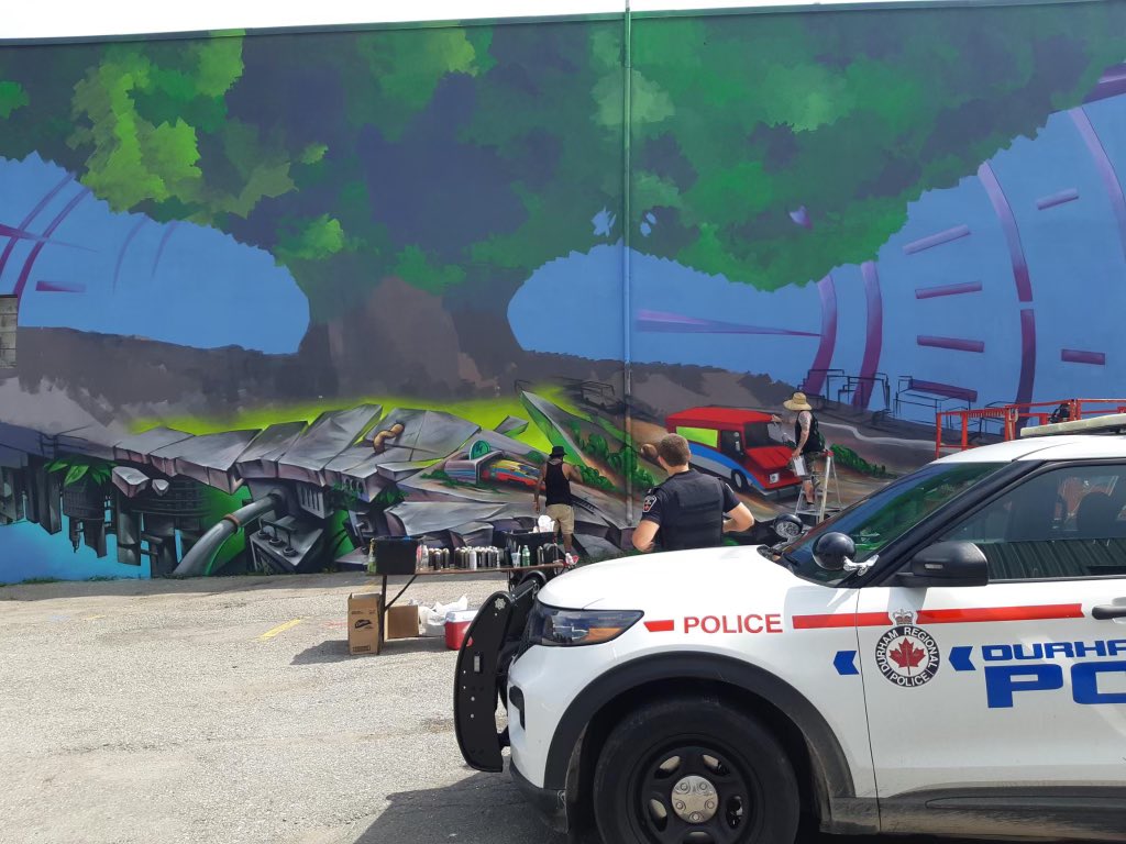 DRPSCEDiv's tweet photo. Cst Ritchie from our #DowntownOshawa bike patrol initiative stopped at 115 Simcoe St S to admire the artwork that is being added. If you’re in the area be sure take a drive by to check out the mural! #Community https://t.co/wmZOH5qQMC