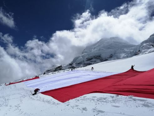 IncMachu's tweet photo. The Peruvian Bicentennial Flag project consists of the placement of a Peruvian flag 200 meters long by 20 meters wide on the top of Peruvian Andes ranges.  The Peruvian flag is already flaming at the top of the imposing Huascarán snow-capped mountain! #machupicchuinc #hikingperu https://t.co/hLb0UywUkz