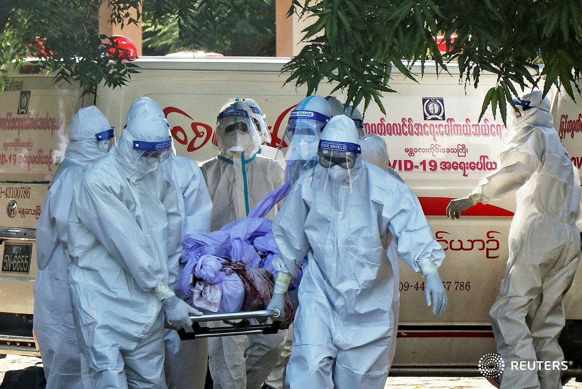 Volunteers pray in front of bodies of people who died due to the coronavirus disease (COVID-19), during their funeral at a cemetery in Mandalay, Myanmar July 14, 2021. REUTERS/Stringer
