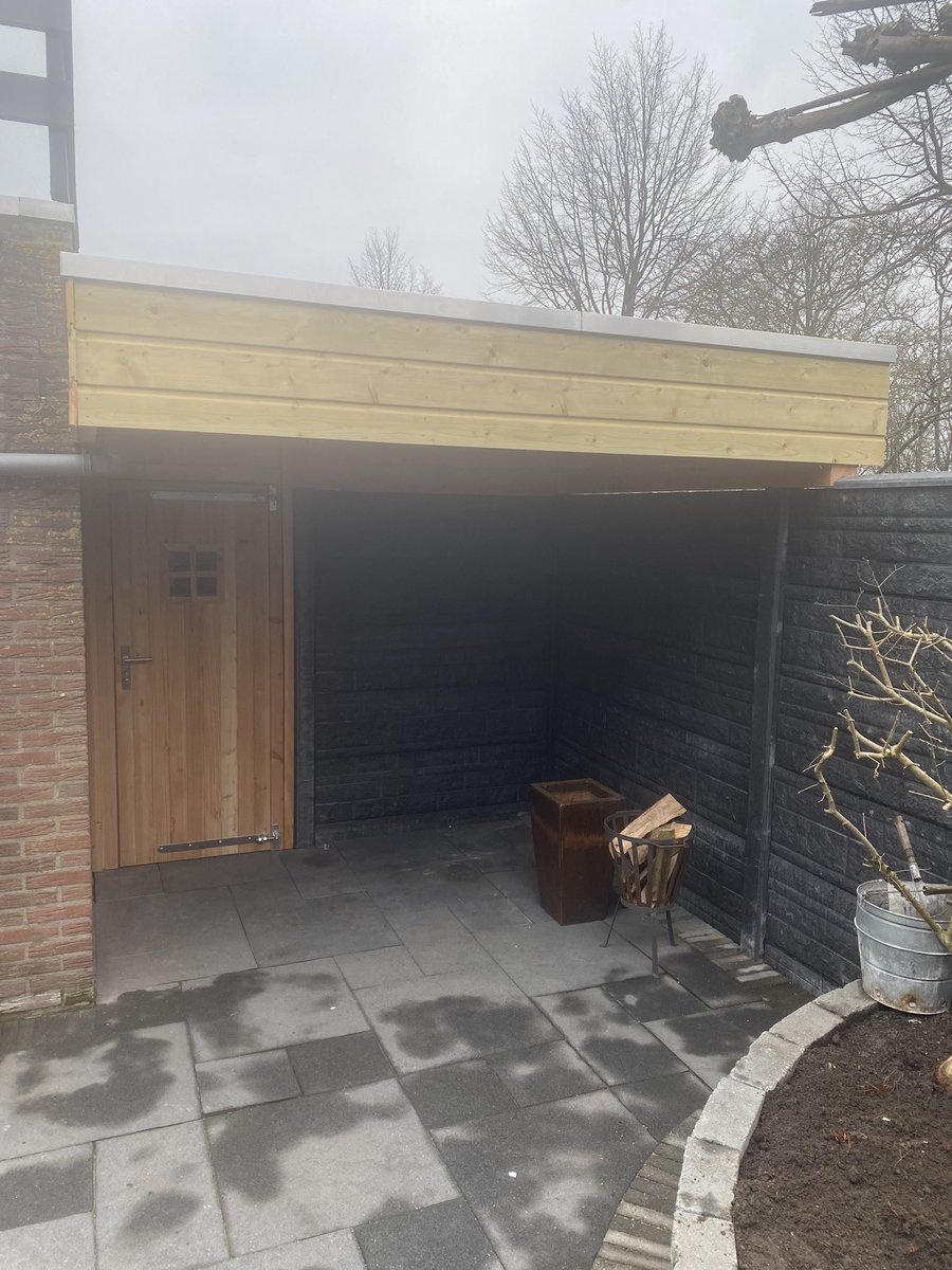 Schutting geplaatst met rotsmotief platen. Dat was meteen de basis voor het nieuwe dak zodat er een nieuw houthok en een nieuwe schuur gebouwd kon worden.