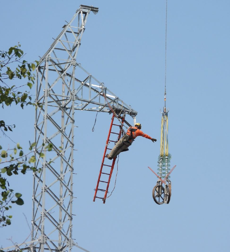 wataynikaneyap's tweet photo. On the #WatayPower Transmission Line Project, an insulator with travellers attached is lifted to a stringing crew member and hung on the “arm” of the tower structure #IndigenousOwnership #OntarioEnergy #Linethatbringslight https://t.co/Ga4hdpavx0