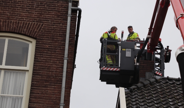 Brandweer maakt in Asperen dakgoot schoon om wateroverlast te voorkomen