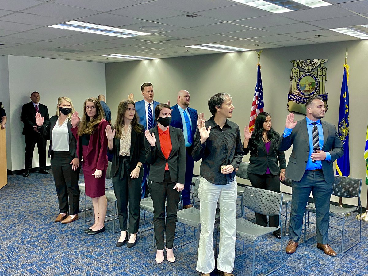 Ten newly hired officers stand with right hands raised