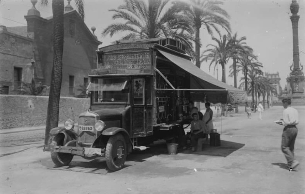premsahistoria's tweet photo. Venda de begudes des d'un camió, al passeig de Colom de Barcelona. Sobre la cabina del camió hi ha un rètol on hi diu "Autos-bars modernos. ünico representante para la venta de coches J.Rovira". 1920-1939 foto de Gabriel Casas ANC https://t.co/a02noXT2Sa