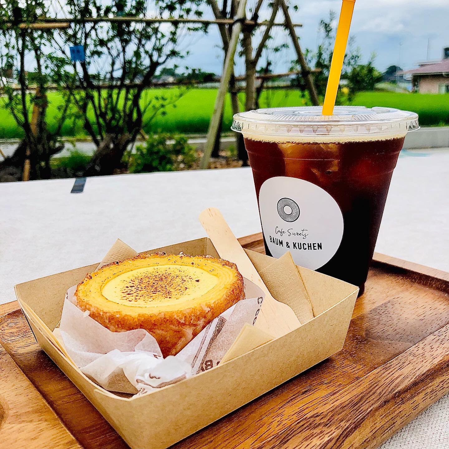 さんいんキラリ 大山町末長にできたカフェ Baum Kuchen に行ってみた 山陰道大山 インターを降りてすぐ 田んぼに囲まれた保育園隣にありました モダンなウッディな建物横にはドッグランや芝生のガーデンテラス席 ガラス張りの壁面とモルタル床