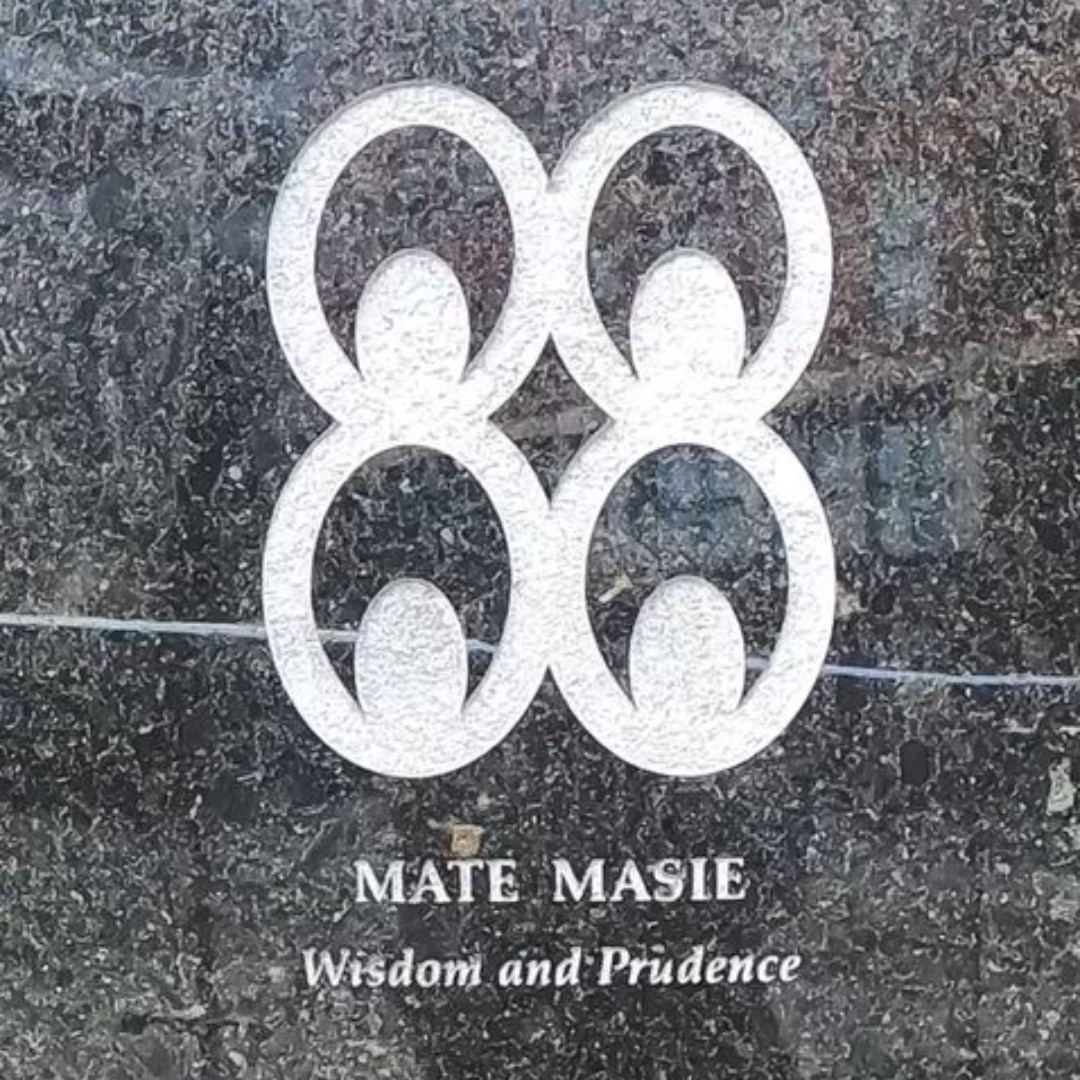 Image: Color photograph of the Mate Masie symbol at the outdoor memorial.