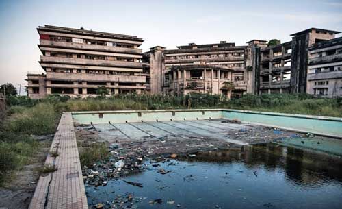 Global_Folder's tweet photo. Grande Hotel in Beira, Mozambique was one of the most luxurious hotels in Africa. It had an Olympic pool. It opened in 1955 but was abandoned by Portuguese in 1974. It later served as an army base and a prison. The Hotel is now a small slum hosting about 3,500 people. https://t.co/0enqEF1KAx