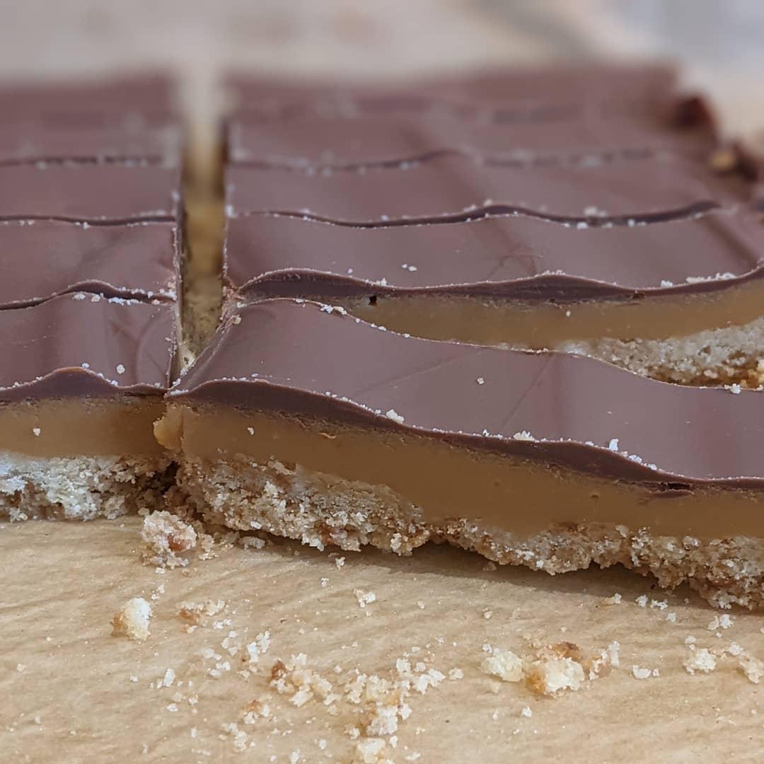 The classic caramel shortcake is quickly becoming our most popular sweet treat. Baked by the AllSaints team, we start by making a crumbly shortbread base, top with smooth caramel and cover with milk chocolate.#bakedatallsaints #caramelshortcake #baking