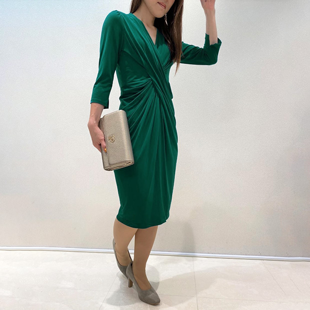 For adding a glamorous touch to your outfit, you can never go wrong with  gold. Our shop staff Midori wears the Green Venus Drape Dress with our  Champagne Gold clutch-style bag. See