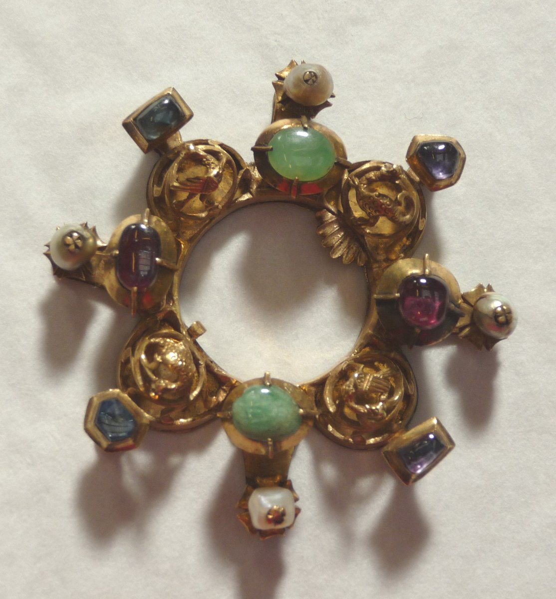 Medivesper's tweet photo. Gold annular brooch with 4 winged beasts set with pearls, emeralds, and blue and pink sapphires. Its pin is missing. 14th century, Hungary

https://t.co/OzvWY7CZl4 https://t.co/ln6mRyM0NY