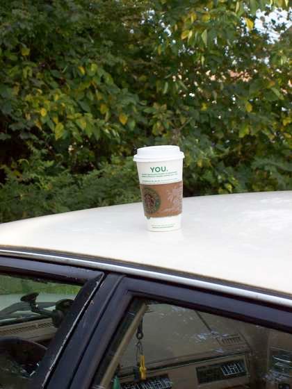 @starbucks cup on roof of car.