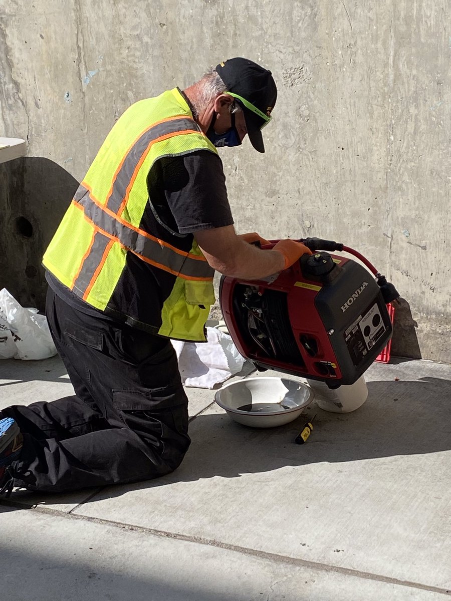 CERT Member removing old oil from a generator.