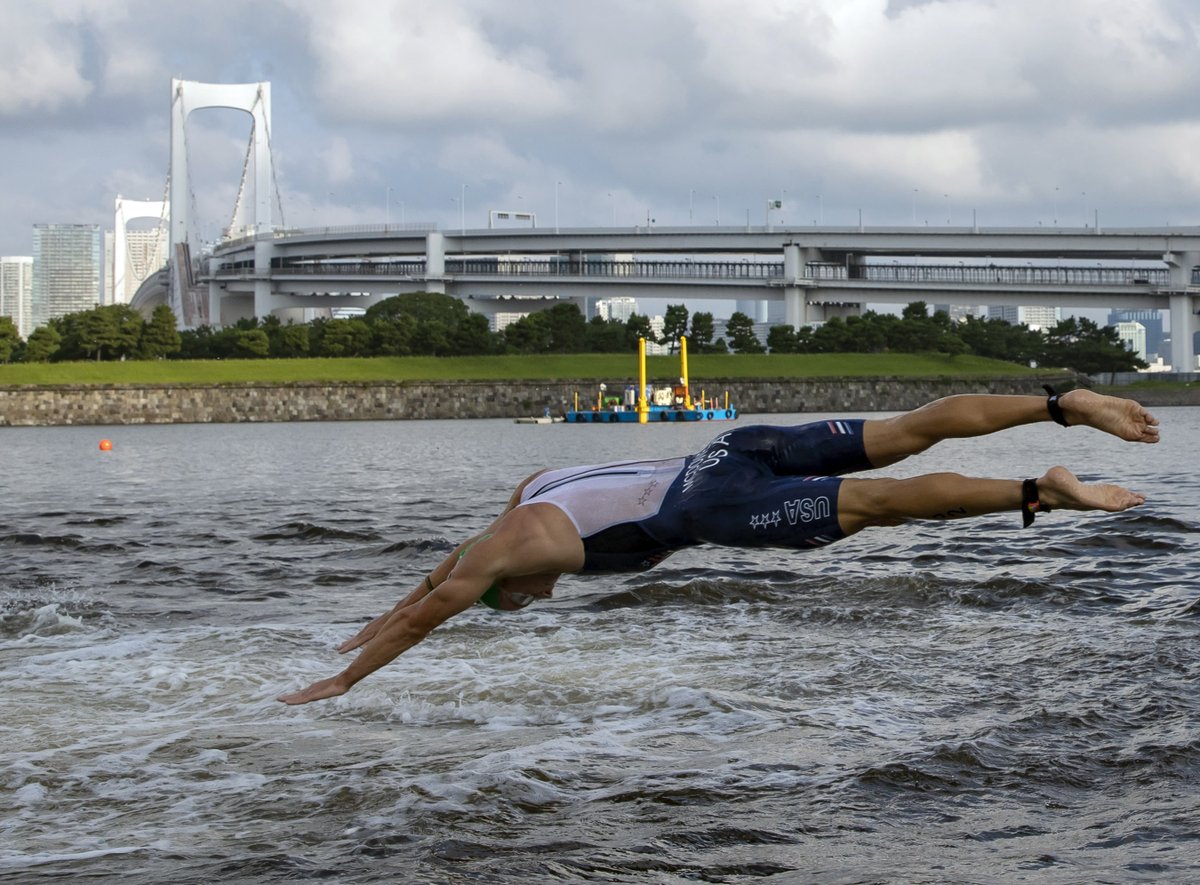 With a backdrop of Rainbow Bridge, USA’s Kevin McDowell dives back into Tokyo Bay for his second lap of the swim in the triathlon. His 6th place finish was the best by an American man in the Olympics. <a href="/StacyStClair/">Stacy St. Clair</a> on his story to get here after cancer: chicagotribune.com/sports/olympic…