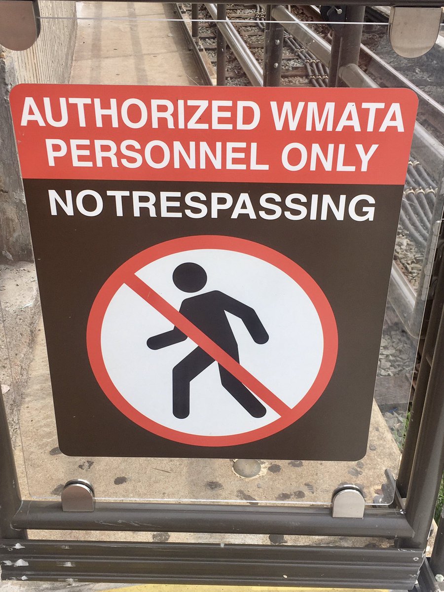 DC metro sign that reads “Authorized WMATA Personal Only” which is white text on red background. Then white text on brown m that reads ”No Trespassing”. The visual issue is the last two words are so close together it looks like one word instead of two.