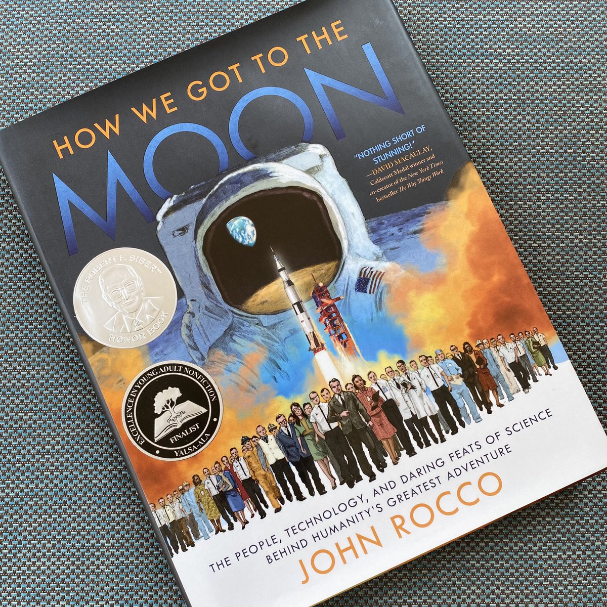 Working on (&amp; enjoying!) my DHS Summer Reading — #HowWeGotToTheMoon by <a href="/johnroccoart/">John Rocco</a>. It’s beautifully detailed &amp; researched &amp; I’m eager to discuss it w/ students! #SummerReading #SummerReading2021 #readingforpleasure #lifelonglearning #nonfiction #spaceexploration <a href="/dedhamhs/">Dedham High School</a>