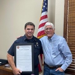 Retiring Battalion Chief Dave Livingstone receives a Proclamation from Fire Board President Jim Ashcraft in honor of his 31 plus years of service with the Fire District.