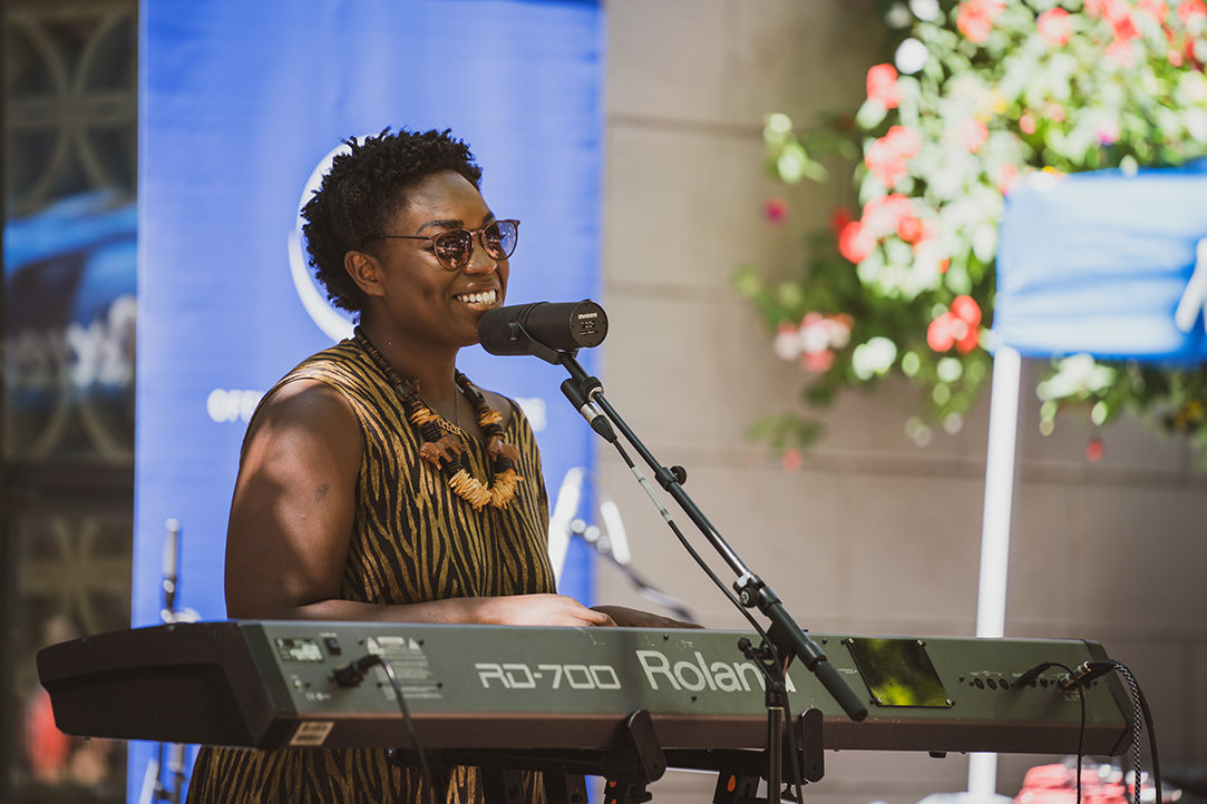 Shaina Shepherd playing a keyboard and singing into a mic