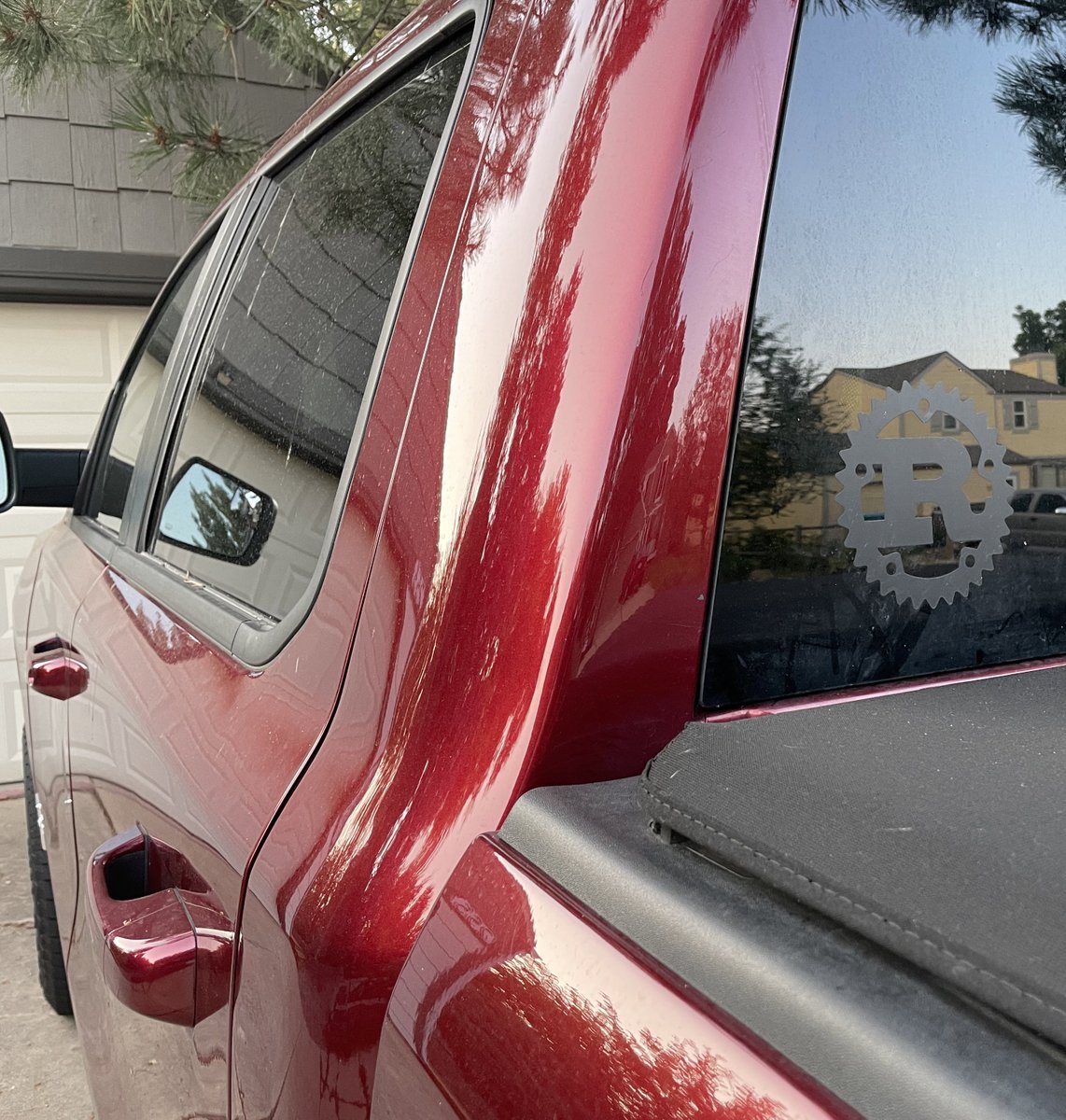 a truck with the Rust programming language sticker on the back window.