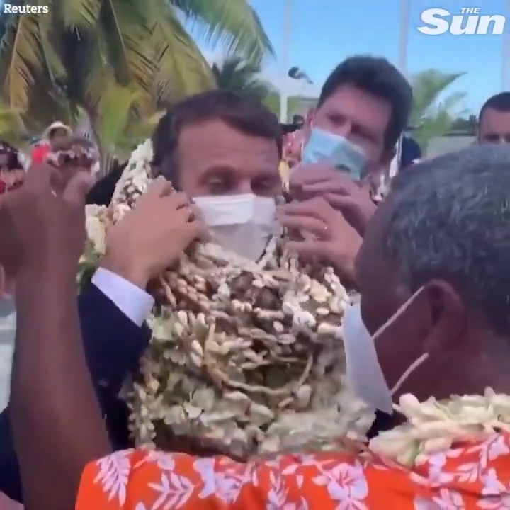Emmanuel Macron becomes a 'walking flower' as he sinks under flower garlands in French Polynesia