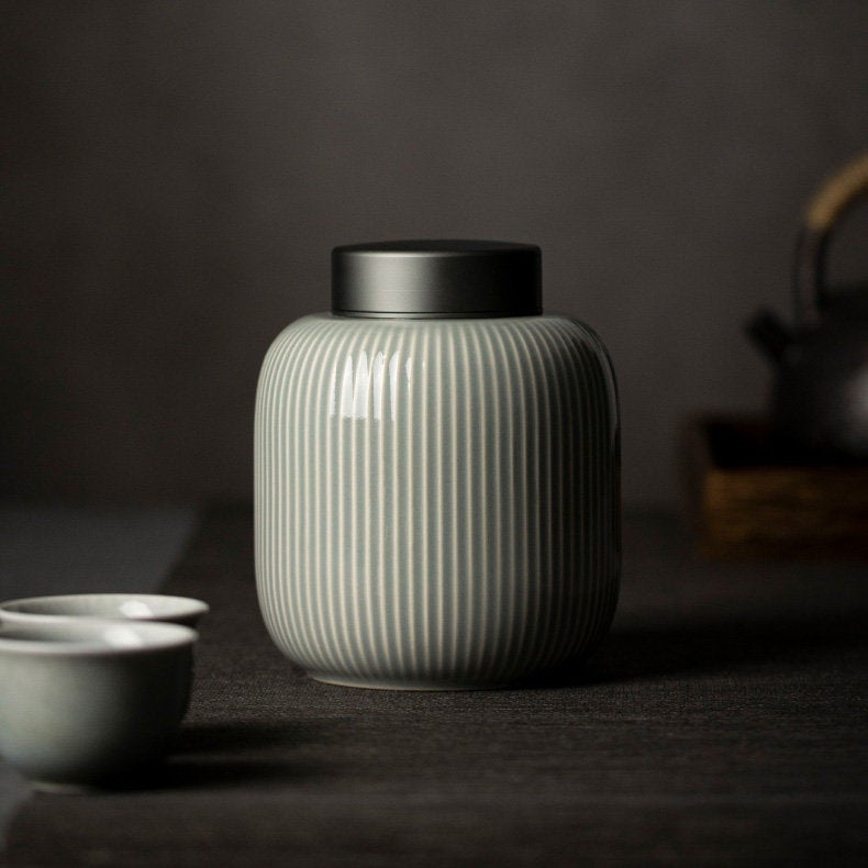 This high-quality tea canister is handmade by porcelain artist-craftsman based in Fujian, China. The elegant shape and vertical strip design give it a modern and sleek appearance