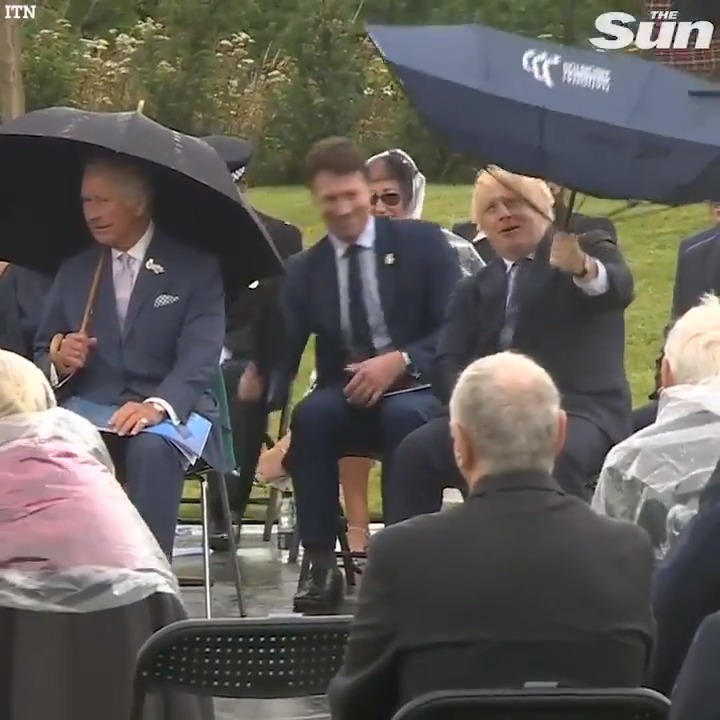 Prince Charles giggles as Boris Johnson struggles with his umbrella