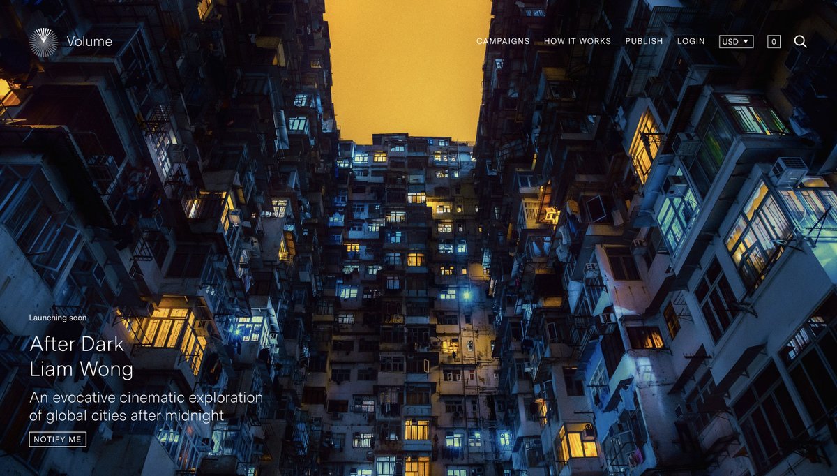 A screenshot of the landing page for the website vol.co - a large cinematic shot of Hong Kong's residential architecture. The sky is yellow, the buildings are blue in color. The image and angle are overwhelming - looking upwards at many floors towering over the viewer.