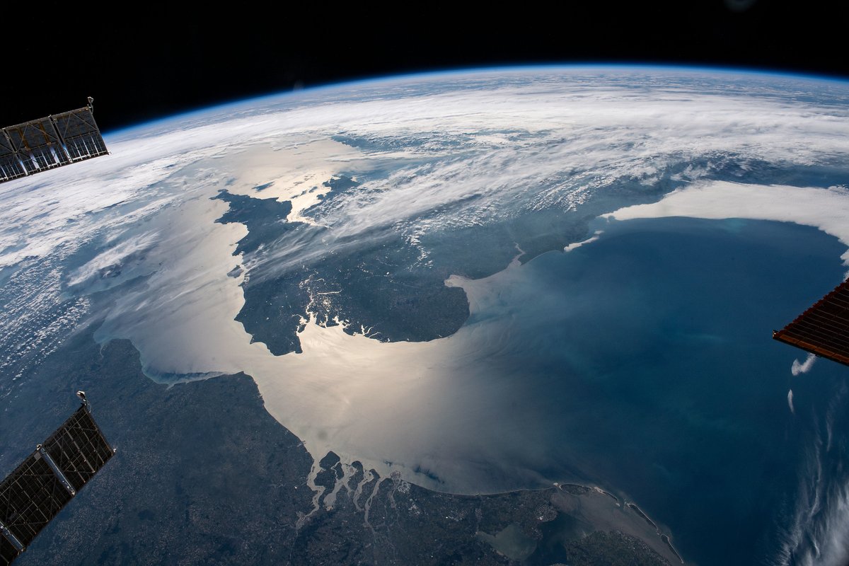 English Channel photographed from the International Space Station with the solar arrays of docked spacecraft visible in corners of image