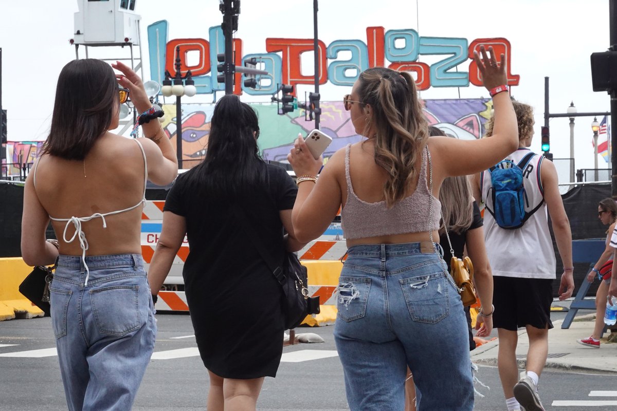 Music fans walk toward a Lollapalooza sign