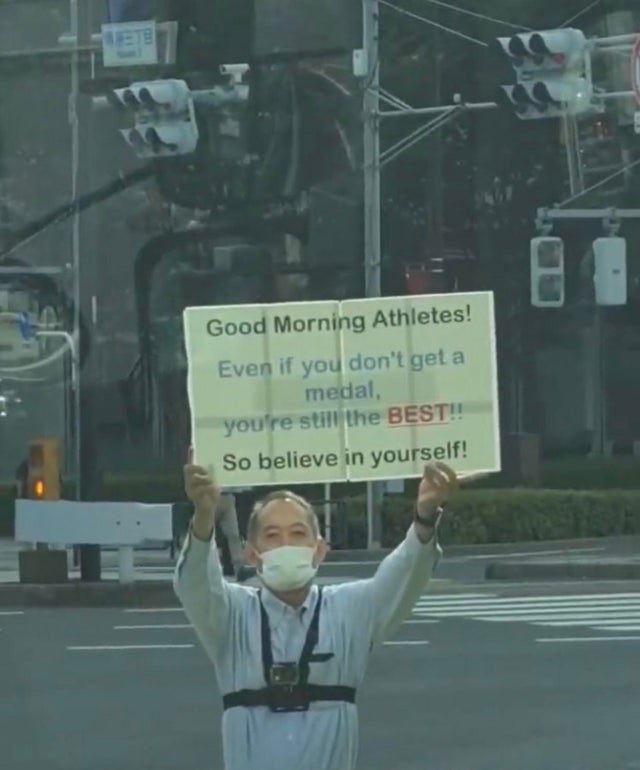 @CNBC this Japanese man greeting athletes with this sign. true #OlympicSpirit #Olympics2021